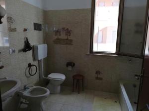 a bathroom with a toilet and a sink and a tub at Villa Giardini in Balestrate +22 photos