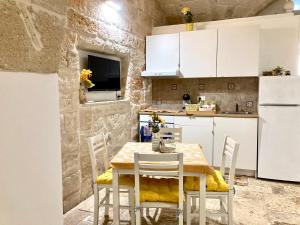a kitchen with a table and chairs in a room at Antica Pietra in Polignano a Mare