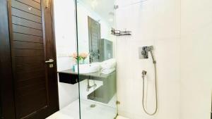 un baño con ducha y lavabo en Olive Service Apartments - Greater Kailash, en Nueva Delhi