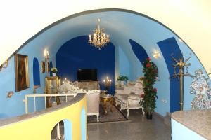a living room with blue walls and a chandelier at Hotel Garni Daniela Urich in Schwanenstadt