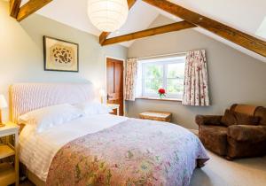a bedroom with a bed and a chair and a window at Nant y Rhedyn Newport in Newport Pembrokeshire
