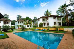 a swimming pool in front of a house at Keys Hotel Mbokomu Branch in Moshi