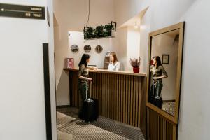 dwie kobiety stojące przy ladzie w hotelu z bagażem w obiekcie Hotel Yarden by Artery Hotels w Krakowie