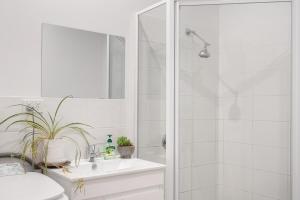 Un baño blanco con ducha y lavabo. en Modern retreat- private entrance - free parking, en Kingston 20 fotos más