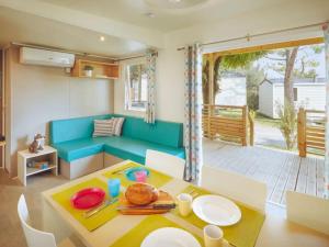 a living room with a blue couch and a table at Valamar Camping Lanterna - Roan in Poreč +24 photos