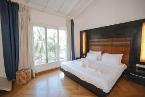 a bedroom with a large bed with a large window at VILLA M - JIA 5 CANDOLIM GOA 3BHK, Pool Facing, Near Beach, Free Breakfast, Free WIFI and Prime Location in Candolim +78 photos