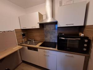a kitchen with a black microwave and a sink at Traumblick Bayerischer Wald, Pool & Sauna, Getränke, Klimaanlage in Freyung