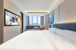Un pat sau paturi într-o cameră la Echarm International Hotel Guangzhou Baiyun International Airport Qingbu Metro Station Branch - Free Deliver Service to Guangzhou Baiyun International Airport & Free Deliver Service to Canton Fair Complex During Canton Fair Period