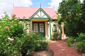 a small house with a pink roof and a brick driveway at The Dove Cote in Tanunda