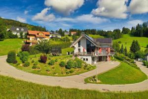 a house on a green hill with a driveway at Ferienwohnung Bergahorn in Todtnauberg