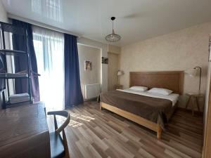 ein Schlafzimmer mit einem Bett und einem großen Fenster in der Unterkunft Hotel cozy jano in Tbilisi City