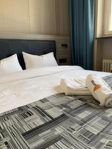 a bed with white sheets and pillows on it at Mooncity Hotel & Boardinghouse in Frankfurt +33 photos