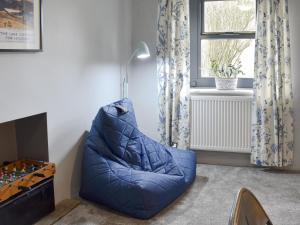 a blue bean bag chair in a room with a window at Toms Cottage in Melmerby