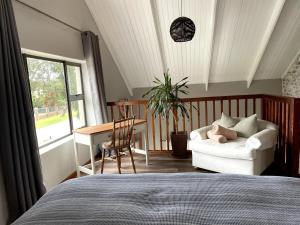 a bedroom with a bed and a table and a couch at Loft on Honey in Sunridge Park