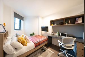 a bedroom with a bed and a desk and a chair at Canvas Wembley in London in London