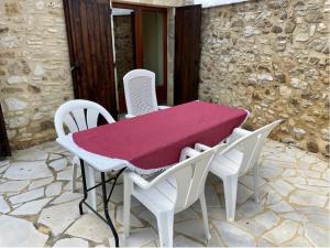 einen Tisch und Stühle mit einem rosa Tuch auf einer Terrasse in der Unterkunft Maison de campagne pour 4 proche de Sarlat in Saint-Martial-de-Nabirat