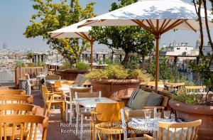 a restaurant with tables and chairs and an umbrella at Villa M in Paris