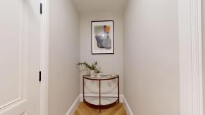a small table in a hallway with a picture on the wall at Smart Stays Suites in Sloane Square in London +71 photos