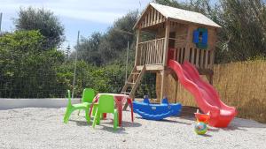 une aire de jeux avec toboggan, chaises et structure de jeu dans l'établissement Sea Queen Villa, à Kato Daratso