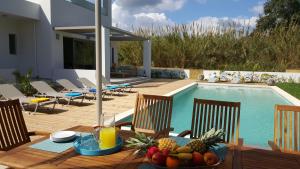 a table with fruit on it next to a swimming pool at Sea Queen Villa in Kato Daratso
