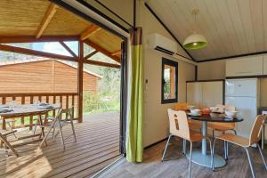 una sala da pranzo con tavolo e sedie su una terrazza di Les Lingoustes - Cottage climatisé avec piscine a Solliès-Toucas