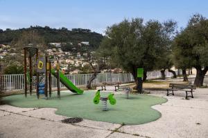 un parco con parco giochi con scivolo e panchine di Les Lingoustes - Cottage climatisé avec piscine a Solliès-Toucas