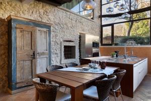a kitchen with a wooden table with chairs and a sink at Ca' del Buso Cottage in Montecchio