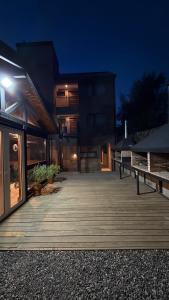 a large building with a wooden deck at night at Ballester's Dream in San Martín de los Andes