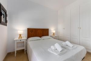 a bedroom with a white bed with two white towels at Coto Real Apartment with Pools & Big Terrace in Manilva