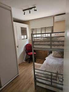 1 Schlafzimmer mit 2 Etagenbetten und einem roten Stuhl in der Unterkunft Pure luxury and comfort La Oliva in La Playa de Tauro