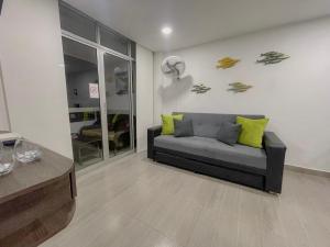 a living room with a couch with yellow pillows at Polanco Residences Tocagua Cartagena - Colombia in Cartagena de Indias