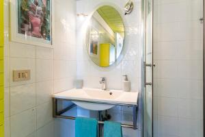 a bathroom with a sink and a mirror at GuestHost - Lovely Apartment with Garden and Parking in Chioma +30 photos