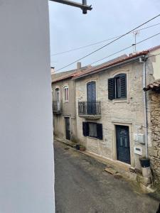 an old stone building with a blue door on a street at Casa Das Aguas Ferreas Bruco in Bruçó