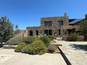 a brick house with some bushes in front of it at Holiday House - Koundouros Panoramic Sea View in Koundouros