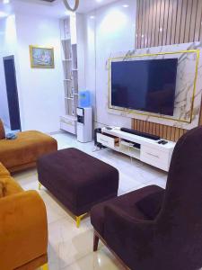 a living room with a large flat screen tv at Monica's Place - One bedroom Lekki Flat in Ikota
