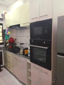 a kitchen with a microwave and a stove in it at Monica's Place - One bedroom Lekki Flat in Ikota