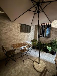 a table and a bench with an umbrella at Pancho House Catania in Catania