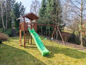 a playground with a green slide in a yard at Chalupa Širůček Budislav in Budislav