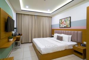 a bedroom with a bed and a desk and a tv at Olive Hotel Hebbal by Embassy Group in Bengaluru +17 photos