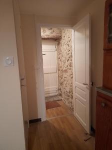 a hallway with a door and a stone wall at Les Citronniers in Belvianes-et-Cavirac