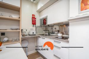 a kitchen with white cabinets and a counter top at #255 Oura Cilla by Home Holidays in Branqueira