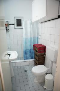 a white bathroom with a toilet and a sink at Trikala Apartments in Tríkala +48 photos