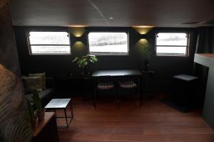 a room with a table and chairs and windows at EUPHRATE HOUSeBOAT in Amsterdam