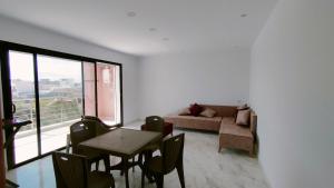 a living room with a table and a couch at Résidence Yasmine in Ksour Essaf