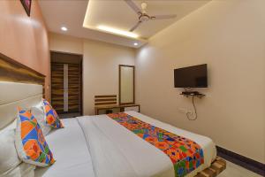 Un dormitorio con una cama y un televisor de pantalla plana. en FabHotel The Wind Palace, en Jaipur