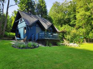 une maison bleue avec un toit noir dans une cour dans l'établissement Modry Domek Szczyrk, à Szczyrk