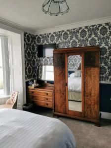 a bedroom with a bed and a mirror and a dresser at Westcliff in Seascale +22 photos