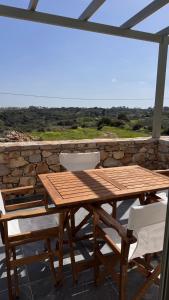 a wooden table and chairs on a patio at Aroniadika rooms in Kýthira