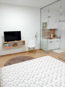 a white room with a bed and a tv at Aura Trebinje 2 in Trebinje