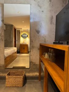 een spiegel in een kamer met een bed en een slaapkamer bij Flex Living Canggu in Canggu +88 foto's